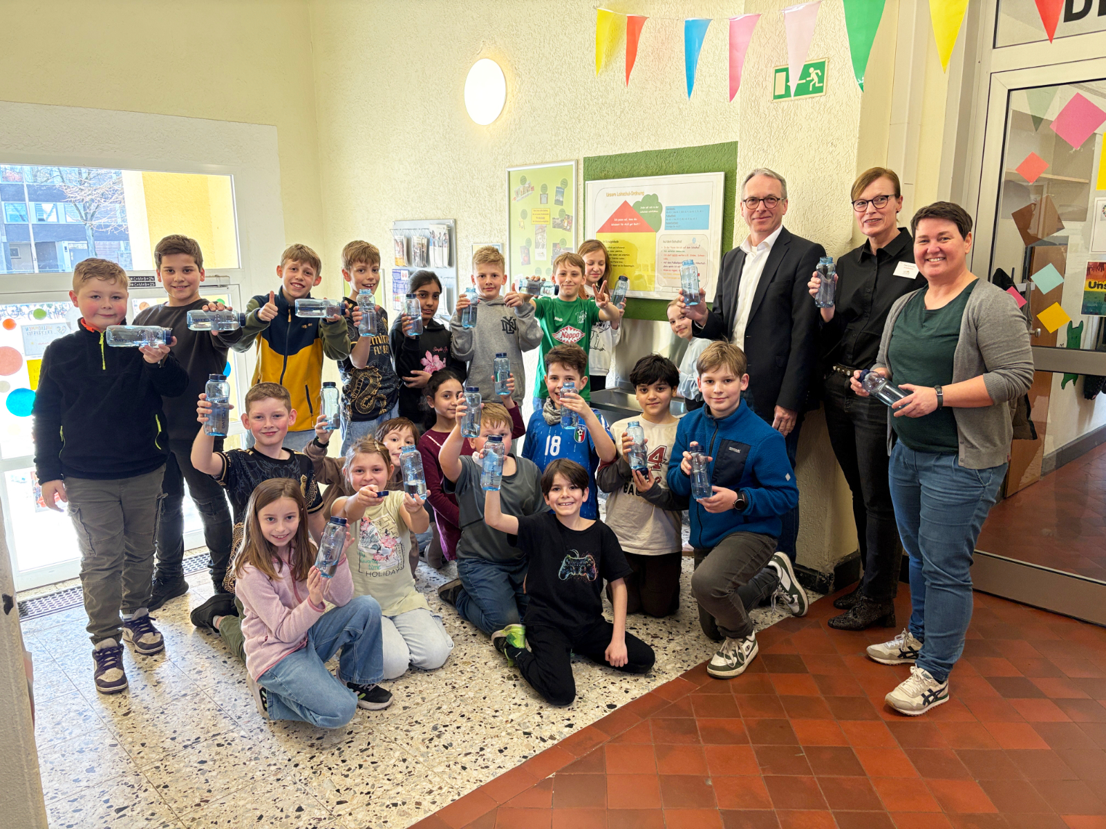 André Dora übergibt Trinkflaschen mit Dattelner Logo